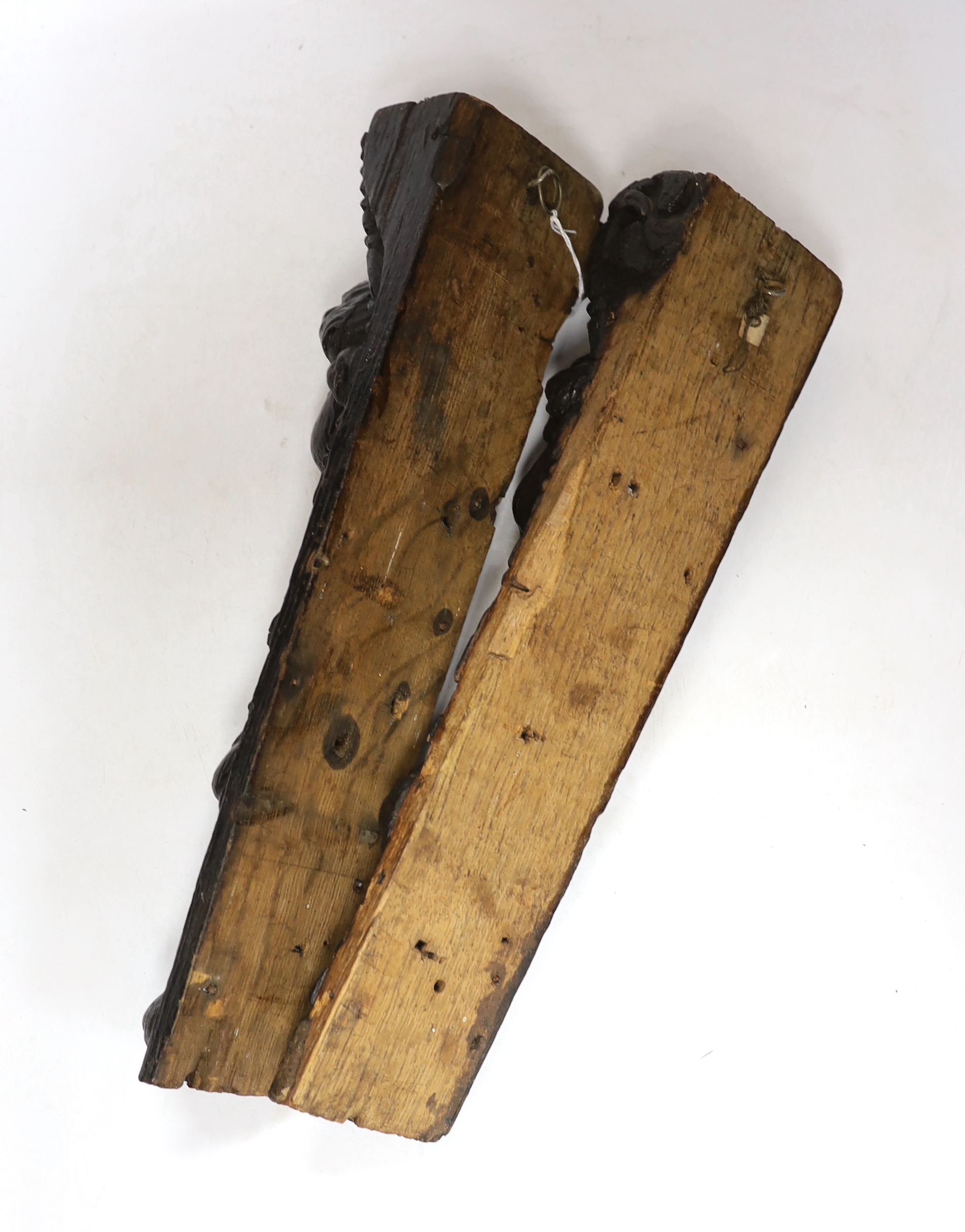A pair of 17th century carved oak jambs, carved with putti decoration, 39cm